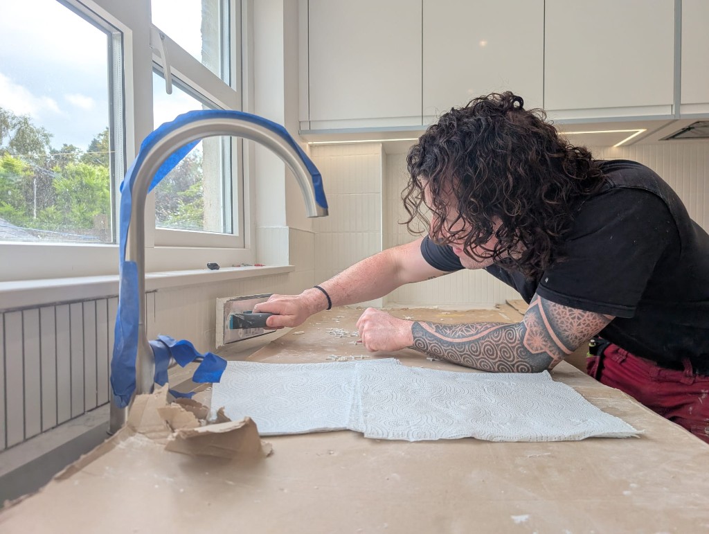 Marc applying adhesive to a kitchen splashback